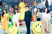 a group of people posing in front of a smiley face