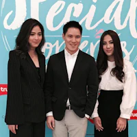 three people standing in front of a sign that says special lovers