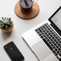 a laptop with a cup of coffee next to it