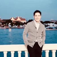 a man standing on a railing near the water