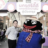 a man standing next to a mascot at an event